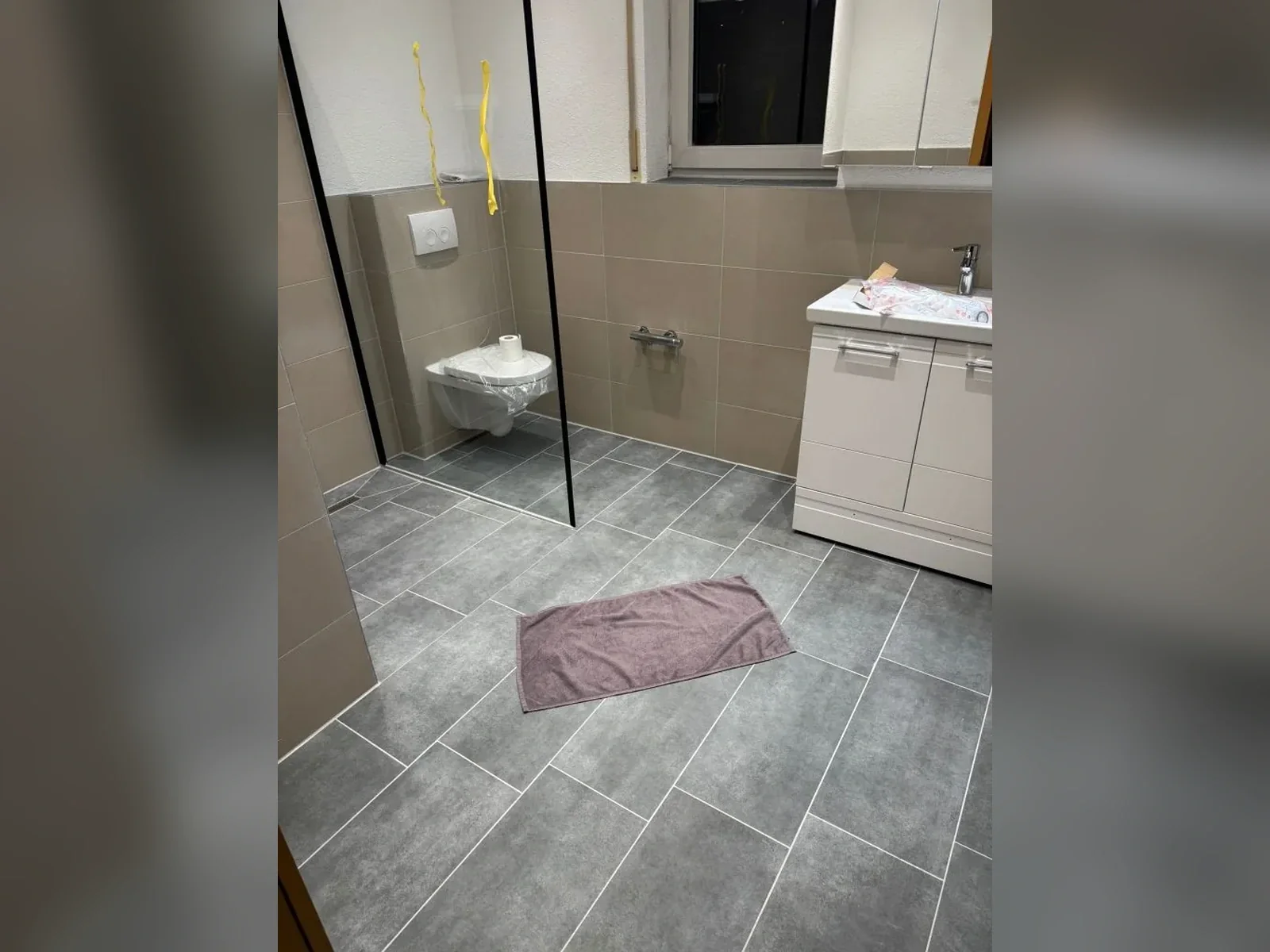 Fertig saniertes Badezimmer mit bodengleicher Dusche nach der Modernisierung Fertig saniertes Badezimmer mit bodengleicher Dusche nach der Modernisierung