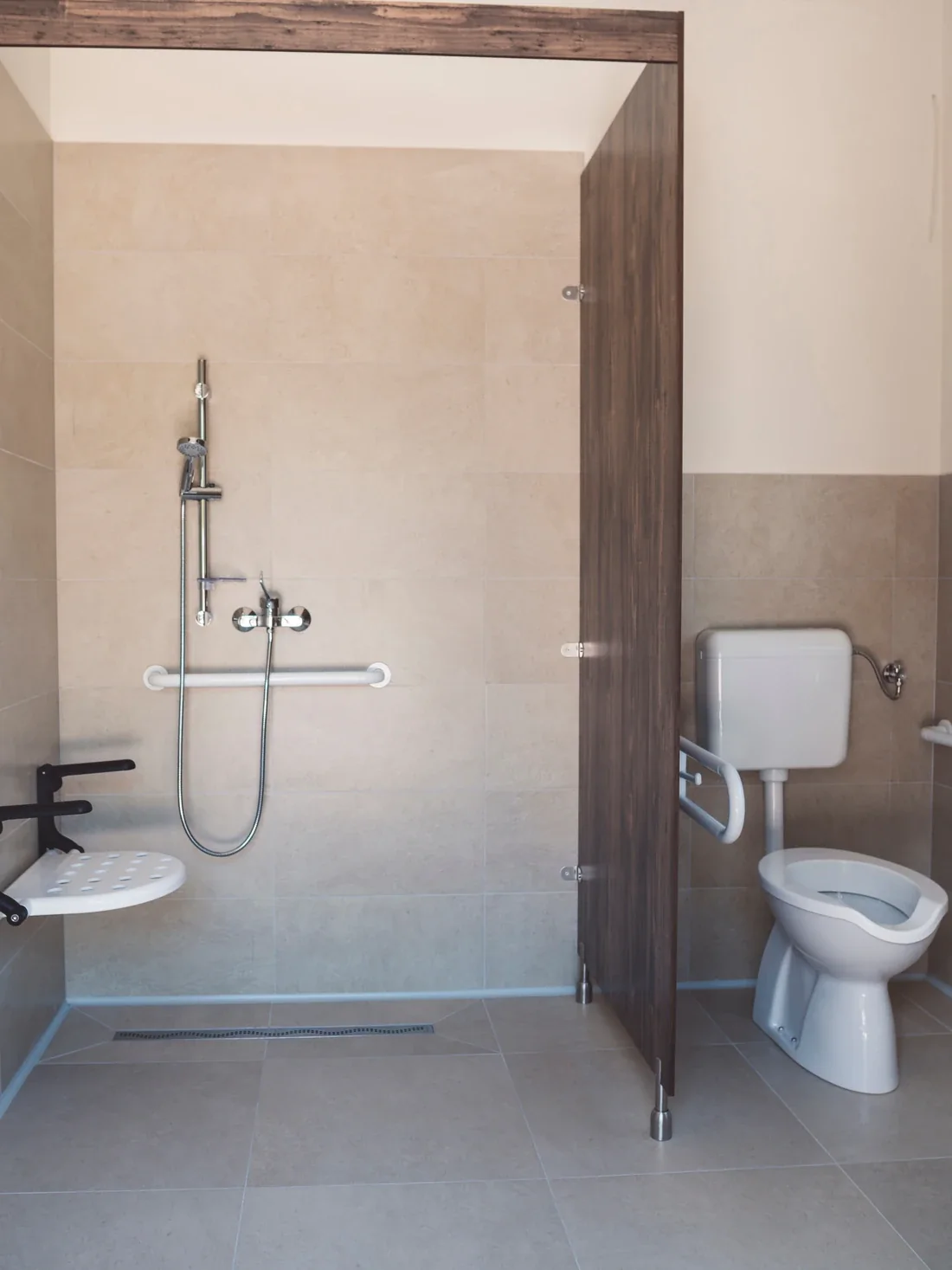 Barrierefreies Badezimmer mit bodengleicher Dusche und sicheren Haltegriffen Barrierefreies Badezimmer mit bodengleicher Dusche und sicheren Haltegriffen
